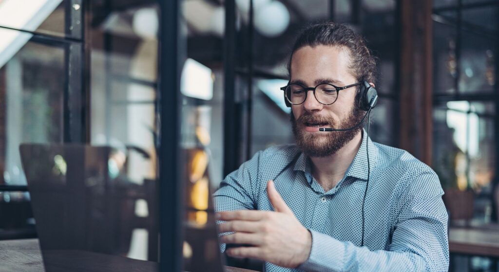 up to data Support | Customer service representative wearing headset in modern office environment