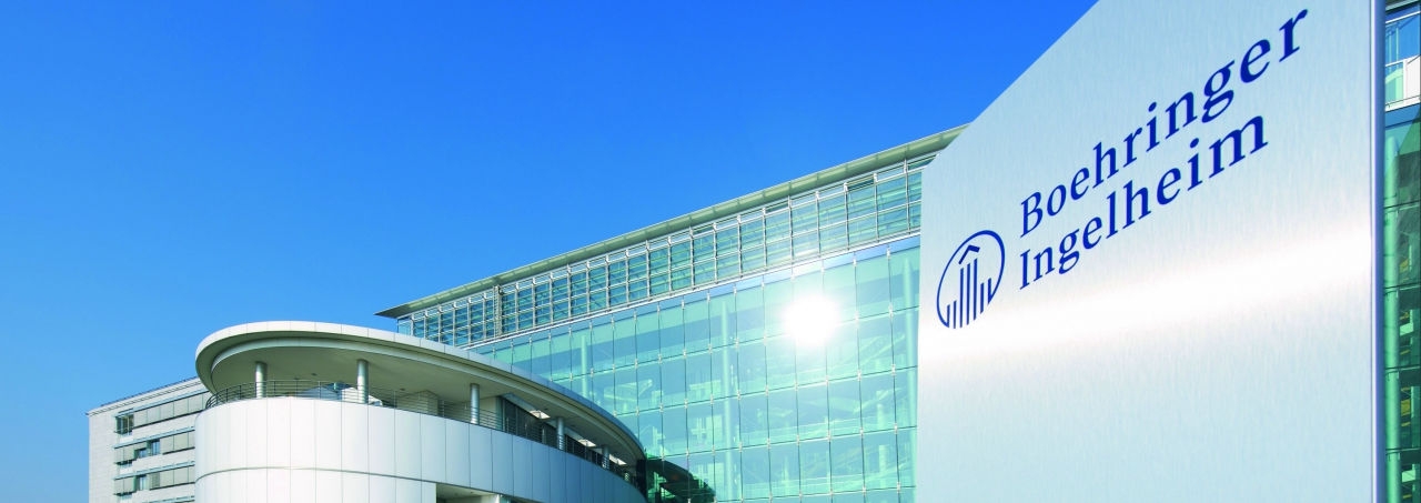 up to data | Boehringer Ingelheim office building with company logo and signage against blue sky